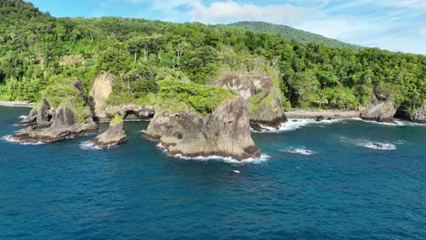 Playa-Batu-Kapal-En-La-Isla-Weh,-Que-Muestra-Una-Exuberante-Vegetación-Y-Una-Costa-Rocosa-Bajo-Un-Cielo-Azul-Claro,-Vista-Aérea