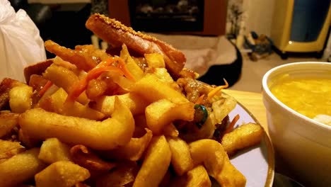 Chinese-takeaway-order,-fattening,-greasy-unhealthy-chips-taken-with-fork-from-plate-dolly-left-across-table-closeup