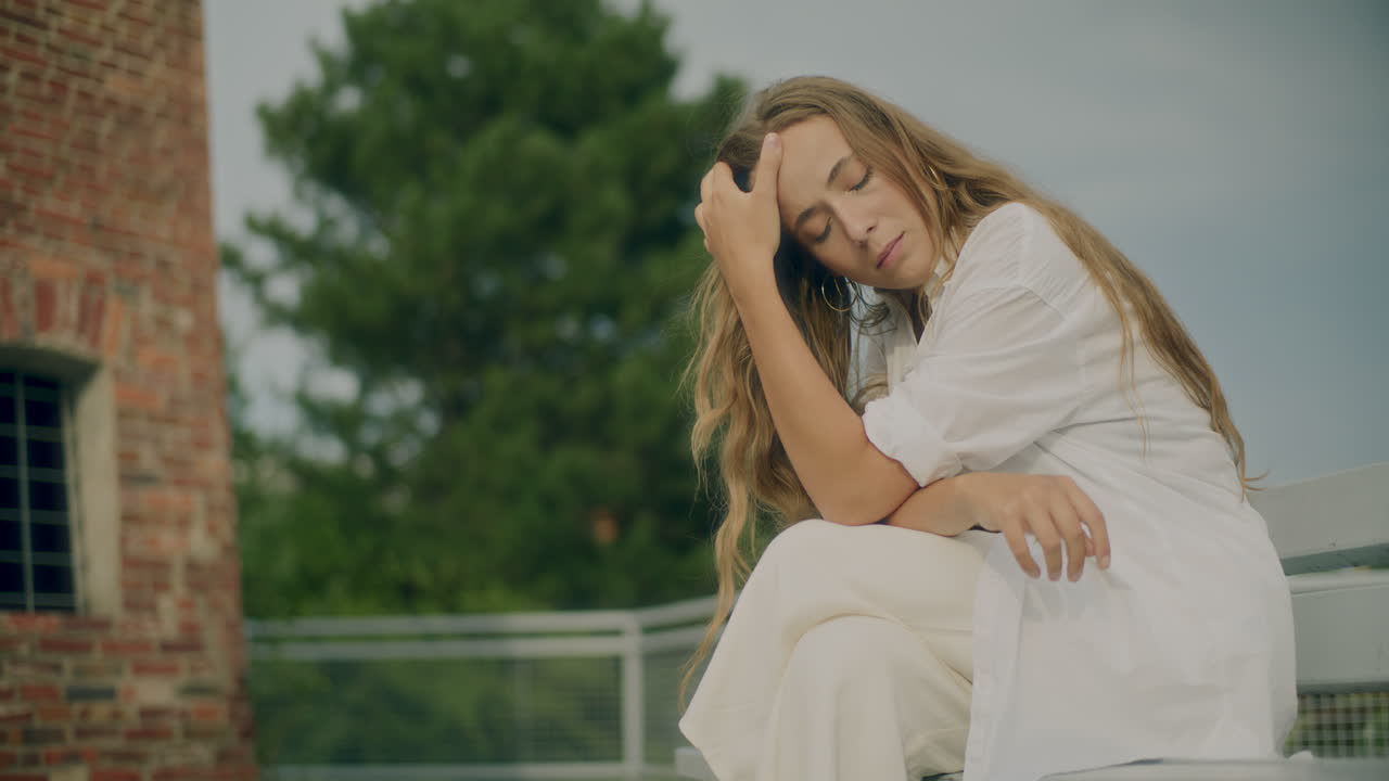 mujer reflexiva en el banco pensando