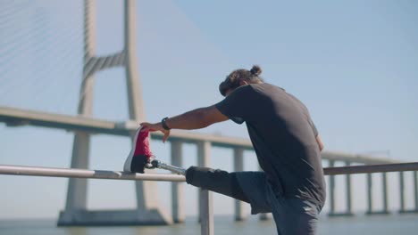 closeup of strong man with prosthesis doing stretching exercise.