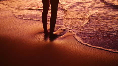 woman stands on the beach on mahé island in seychelles during a beautiful warm sunset