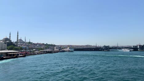 footage of ferryboats and cruise tour boats passing on golden horn part of bosphorus strait in istanbul. eminonu area and galata bridge are in the view.