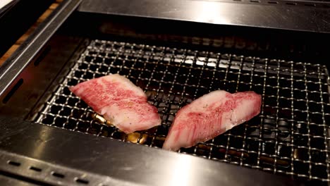 slices of meat cooking on a yakiniku grill