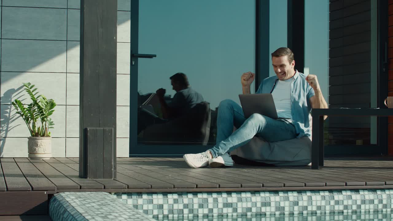 hombre feliz disfrutando de la victoria de negocios. hombre de negocios agitando la mano hablando en la pc