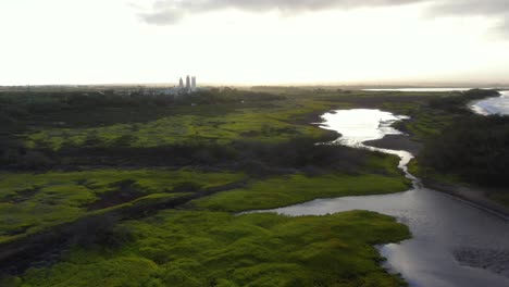 Static-shot-of-maalaea-kealia-fish-pond-during-sunrise-sugar-mill-and-highway-in-background