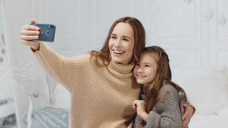 portrait of laughing family posing for mobile selfie in luxury house.