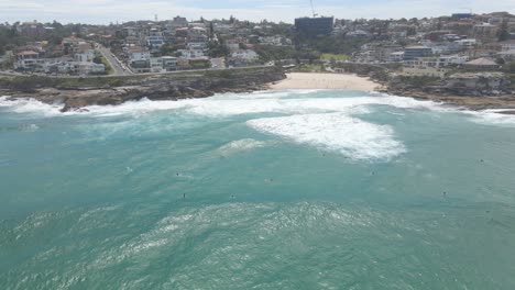 Surfistas-En-Tablas-De-Surf-Flotando-En-El-Océano-Azul---Playa-Tamarama-Y-Bahía-Mackenzies-En-Nueva-Gales-Del-Sur,-Australia