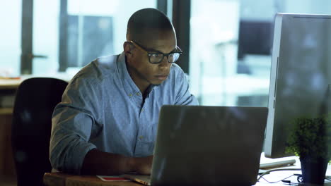 un joven hombre de negocios trabajando tarde en una computadora