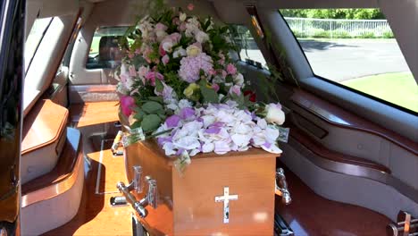 closeup shot of a funeral casket in a hearse or chapel or burial at cemetery