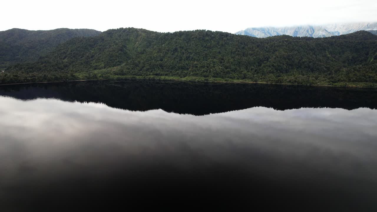 Flying Over Lake Mapourika With Tranquil Water In West Coast, South Island, New Zealand. - aerial shot