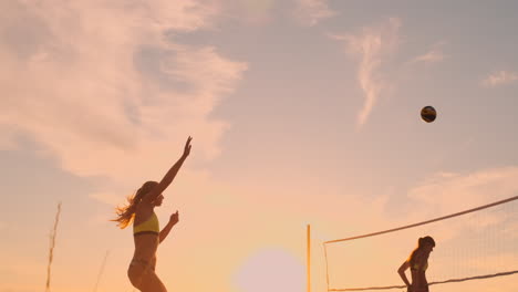 Aufschlag-Beim-Beachvolleyball-–-Frau-Schlägt-Beim-Beachvolleyballspiel-Auf.-Aufschlag-Mit-Überhand-Spike.-Junge-Leute-Haben-Spaß-In-Der-Sonne-Und-Führen-Einen-Gesunden,-Aktiven-Sport-Lebensstil-Im-Freien