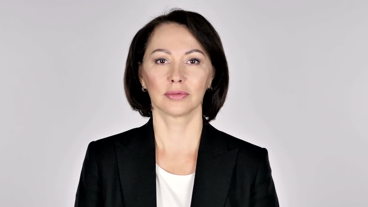 심각한 여성은 색 배경에 스튜디오에서 카메라를보고