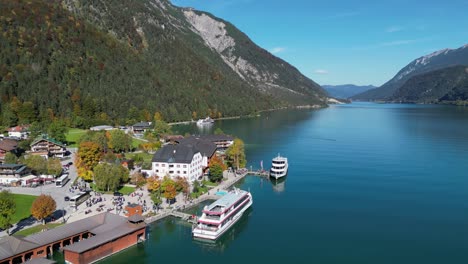 Cruise-Boats-docked-in-Pertisau,-Lake-Achensee,-Tyrol,-Austria---Aerial-4k-Circling