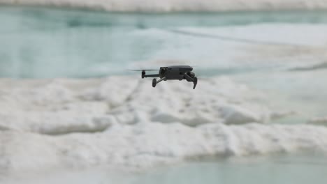 fotografía de seguimiento de un avión no tripulado volando bajo sobre la nieve de invierno y el agua derretida sin persona
