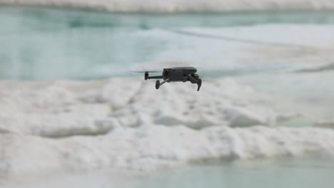 tracking shot of drone flying low above winter snow and meltwater no person