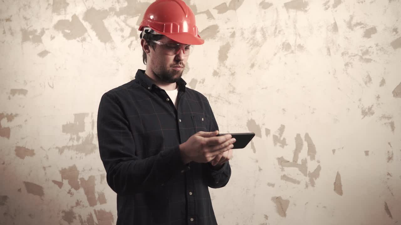 trabajador de la construcción que utiliza un teléfono inteligente en un sitio de construcción