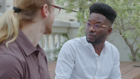 black businessman having conversation with colleague outdoors