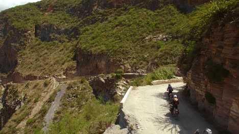 aerial of motorcycle riders riding motorbike on mountain roads