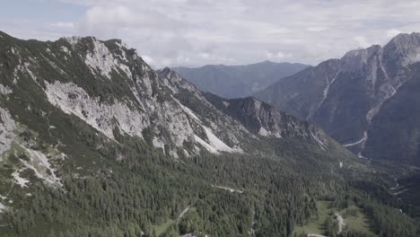 Drone-video-with-revealing-shot-over-the-Vrsc-pass-in-Slovenia-with-mountains-on-the-horizon