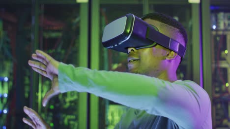 african american male computer technician using vr headset working in business server room