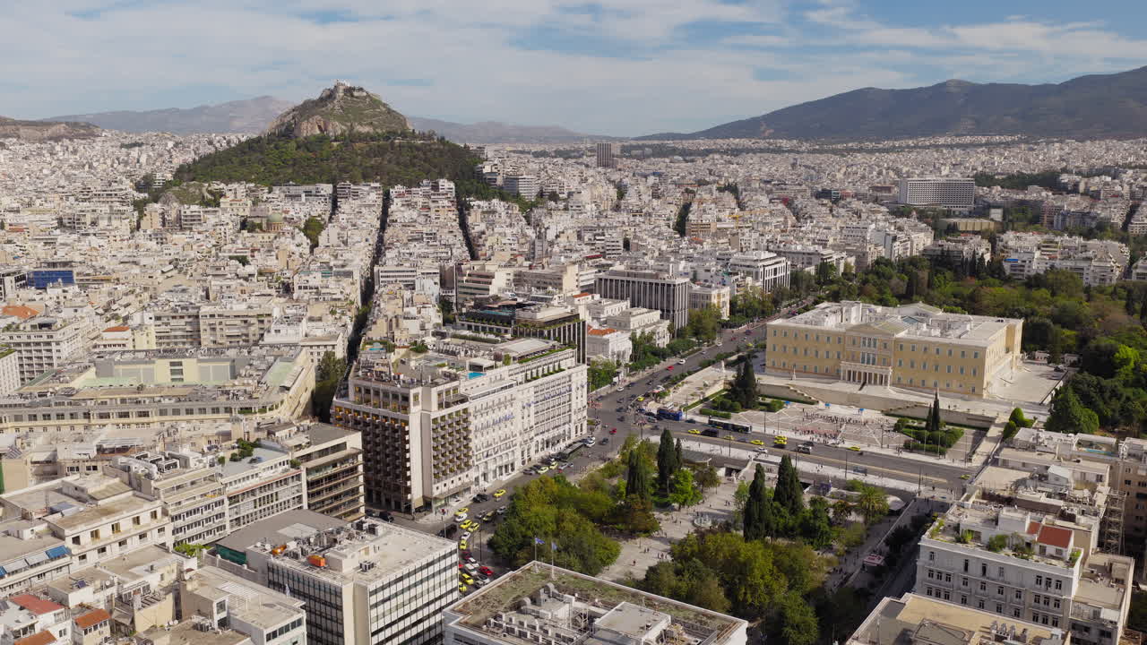 Vista aerea di Piazza Syntagma e degli edifici del Parlamento Greco ad Atene, con taxi e auto che riempiono il primo piano.