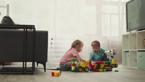 boy holds airplane toy while girl playing with baby doll