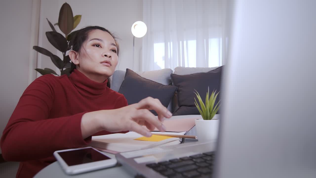 빨간 셔츠를 입은 사업가는 집에서 노트북을 사용하는 데 지쳤다