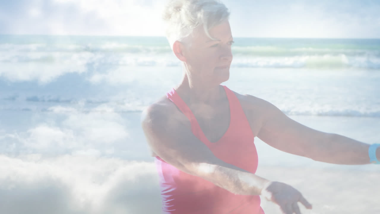 Animazione di luce brillante su una donna anziana felice che pratica yoga in riva al mare.