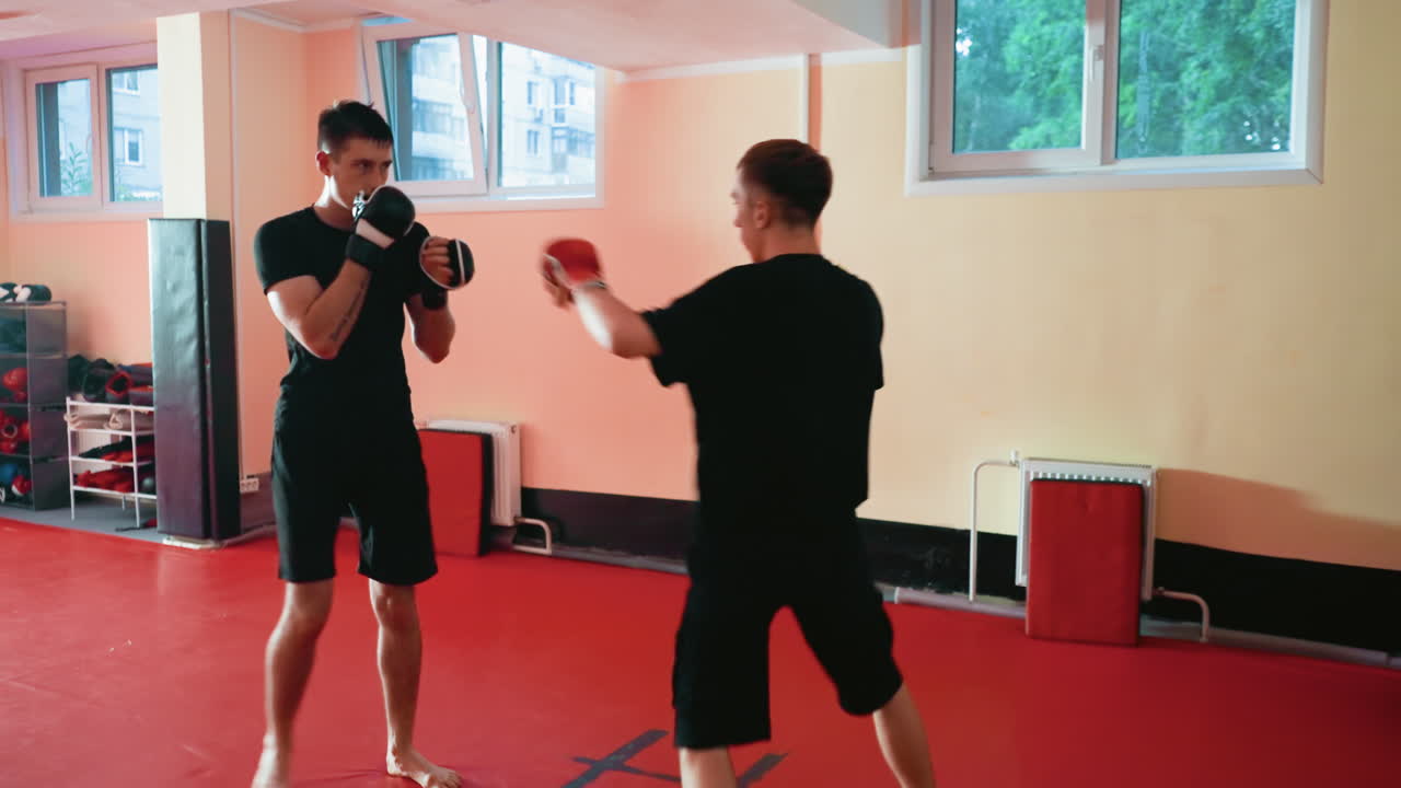 Boxers facing each other inside gym preparing for sparring session, wearing gloves, standing in guard position, focusing on strength, speed, and endurance, showcasing discipline, competitive determination