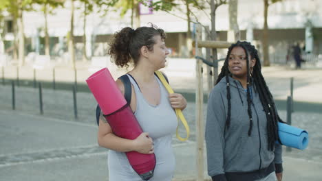 diverse friends walking home through city streets after training