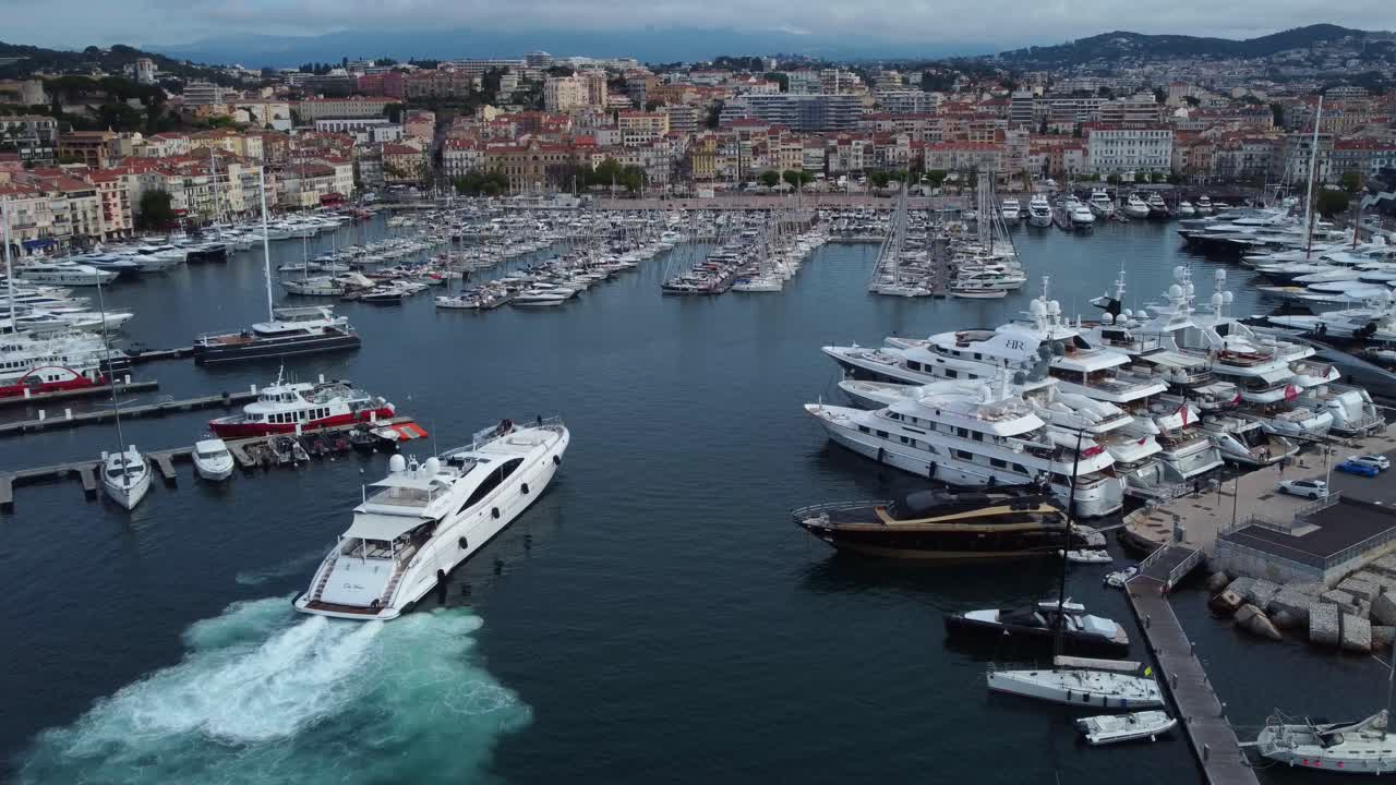 Ripresa con drone di un bellissimo yacht di lusso che arriva e attracca al porto di Cannes.