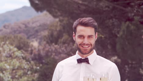 smiling waiter holding champagne glasses