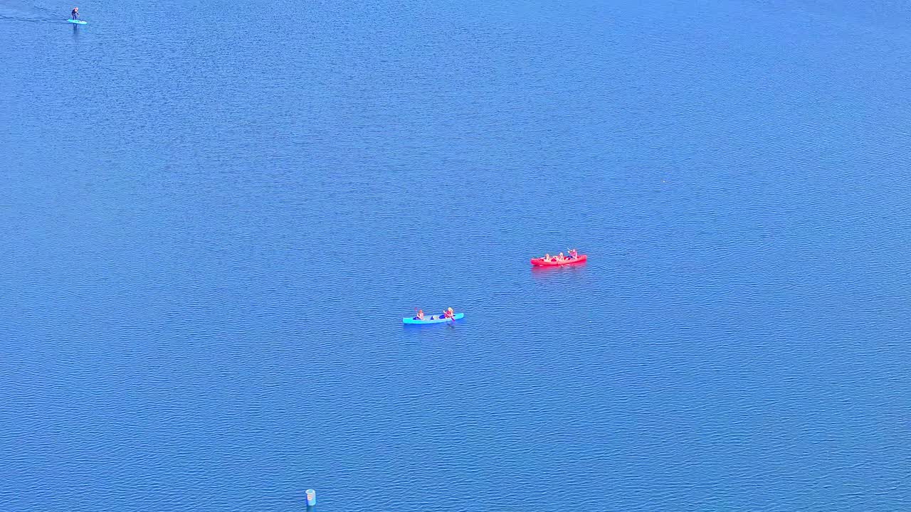 Aerial: two canoes on the lake during the day in Rother Valley Country Park in the Metropolitan Borough of Rotherham, South Yorkshire, England, static drone shot
