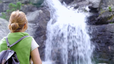 Woman-standing-near-cascade-in-highlands