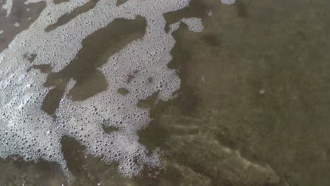 the sea flows over the beach from top right