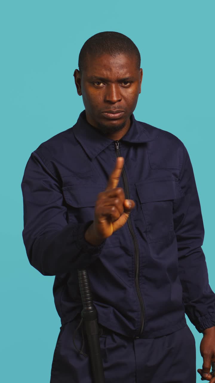 African American Security Guard Warning with Finger Gesture