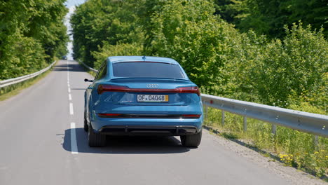 audi e-tron sport electronic vehicle for save environment. new model of luxury automobile driving on a road. green nature background.