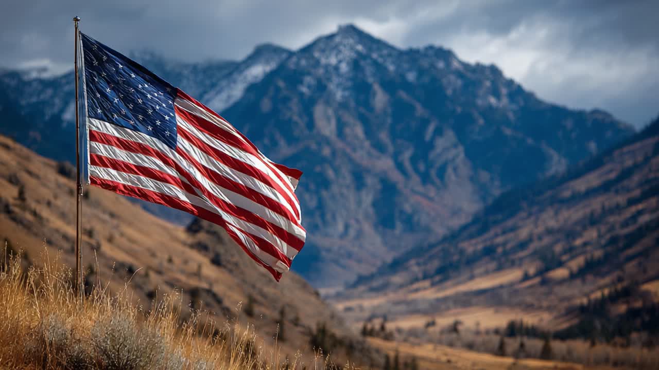 A Majestic American Flag Waves Proudly in Front of a Breathtaking Mountain Range, Capturing the Spirit of Patriotism and Natural Beauty in an Expansive Landscape