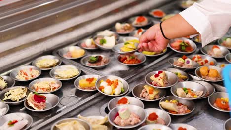 a chef arranges colorful dim sum in a bustling phuket market. bright lighting highlights the intricate details and vibrant ingredients