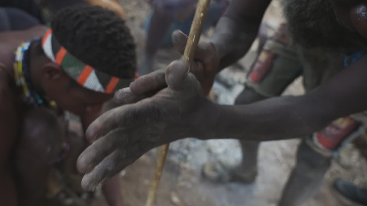 Cinematic shot of tribal african man doing fire with a wood stick. Traditional bushmen tribe, Tanzania, Africa 4K.
