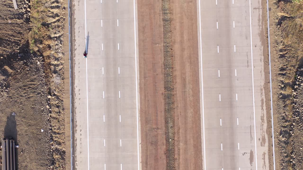 새로운 3차선 고속도로에서 운전하는 모터사이클과 도로변에 파이프라인 발굴