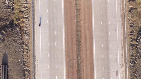 Motocicletas-Circulando-Por-Una-Nueva-Autopista-De-Tres-Carriles-Con-Excavación-De-Tuberías-En-Los-Bordes-De-Las-Carreteras