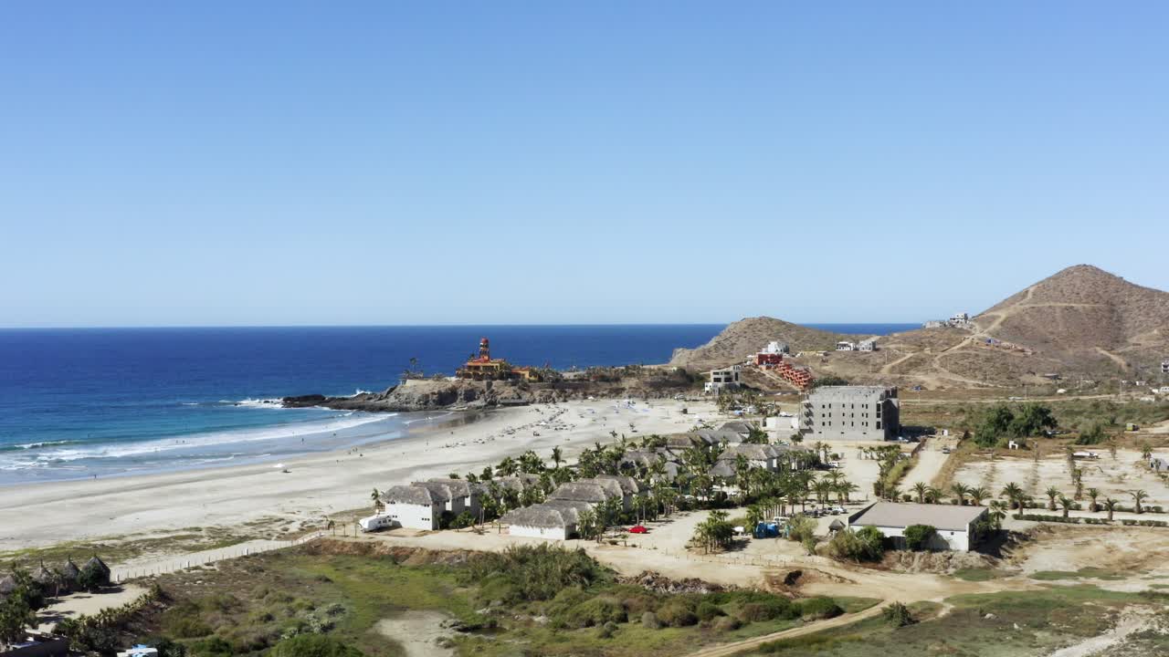 toma cinematográfica súper genial de los acantilados cerca de la playa de los cerritos en un día soleado con las olas de agua azul rompiendo las rocas en méxico, todos santos