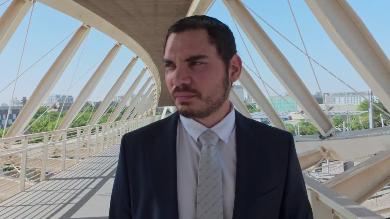 Pensive Young Businessman in a Suit Thinking on a Modern Urban Bridge