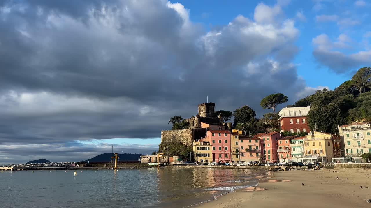San Terenzo, Liguria: cielo suggestivo sul villaggio costiero e sulla baia nel Golfo dei Poeti vicino a Lerici, con castello medievale sul mare, spiaggia e calmo mare Mediterraneo, panorama diurno