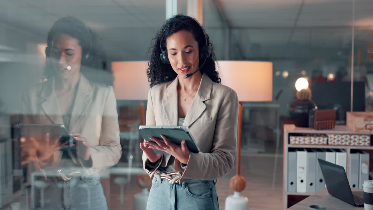 Imprenditrice che utilizza tablet e cuffie in ufficio