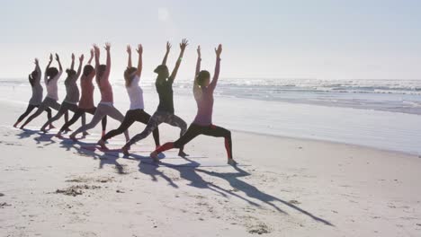 Multiethnische-Gruppe-Von-Frauen,-Die-Yoga-Position-Am-Strand-Und-Im-Hintergrund-Des-Blauen-Himmels-Machen