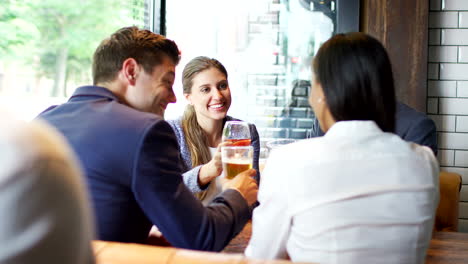 group of business colleagues meeting for drinks and socializing in bar after work