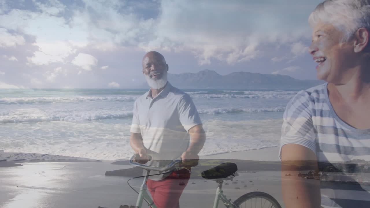 Verticale video: Een vervagende overgang toont een man in poloshirt met een fiets en een vrouw in gestreepte top op het strand die naar de zee kijkt.