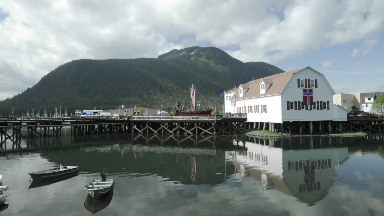 lapso de tiempo de las nubes pasando sobre hijos de noruega hall y barcos moviéndose en hammer slough en petersburgo alaska
